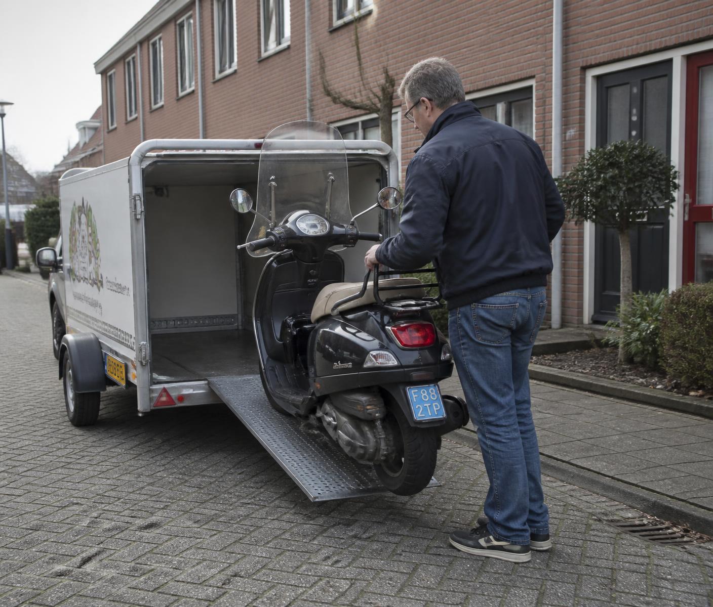 Scooter wordt in een aanhanger geladen voor reparatie